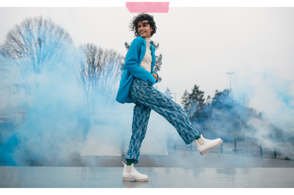 Jeune femme au skate parc, portant des bottines Méduse, fumigènes bleus en arrière plan
