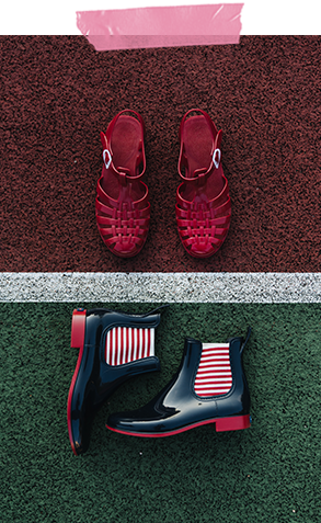 One pair of deep red Méduse jelly sandals and a pair of red soled, black boots with red and white striped elastic on the side.